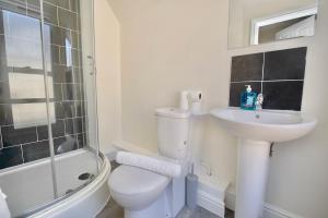 a white bathroom with a toilet and a sink at Belgrade Lodge Studio 4 - Parking, City Centre, Walk to West Orchard Shopping Centre in Coventry