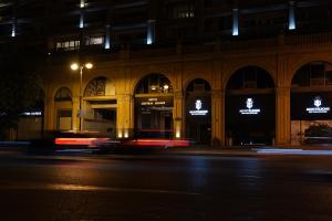 a city street at night with a building at Central Square Hotel in Baku