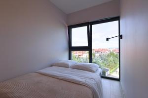 une petite chambre avec un lit et une fenêtre dans l'établissement Apartament #CapitalTower 155 FV, à Rzeszów