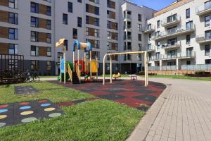 une aire de jeux en face d'un grand bâtiment dans l'établissement Apartament #CapitalTower 155 FV, à Rzeszów