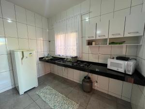 eine kleine Küche mit Kühlschrank und Mikrowelle in der Unterkunft Doce Bruma in Brumadinho