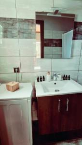 a bathroom with a white sink and a mirror at Olivo Apartment - Studio in Lixouri +18 photos