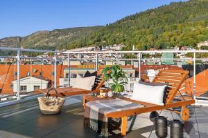 a balcony with two wooden benches on a ship at Top-Floor Gem with City Views in Bergen