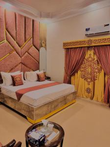 a hotel room with a bed and a table at Galaxy Rezidor in Karachi