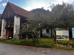 a building with a tree and a sign in front of it at Apartma Pr'Csrlu in Rut