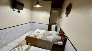 a small room with a bed and a mirror at Pouso Trindade in Trindade