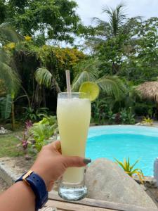 a person holding a drink with a slice of lime at Magic Green Dentro del Parque Tayrona in El Zaino