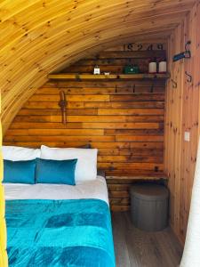a bedroom with a bed in a wooden cabin at Henny Riverside Glamping in Sudbury