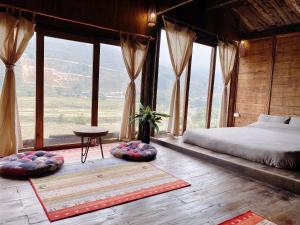 a bedroom with a bed and a large window at Lee Eco House Sapa in Sapa