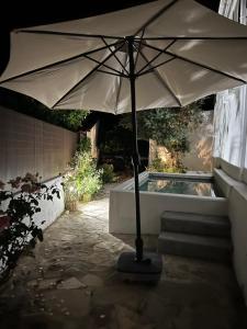 an umbrella sitting in front of a swimming pool at Villa Nooma Alentejo in Vila Fernando