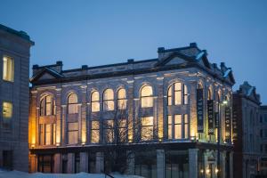 un grand bâtiment en briques avec ses lumières allumées dans l'établissement Hotel Oui GO!, à Trois-Rivières