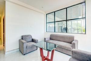 a living room with a couch and a glass table at Super Townhouse Oak LB Metro Station Formerly Sunil Arcade in Surūrnagar
