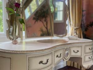 a vase of flowers on a white dresser with a mirror at Garden Apartment in Par +20 photos