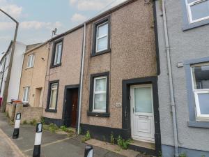 a row of brick houses on a street at Holly House in Whitehaven