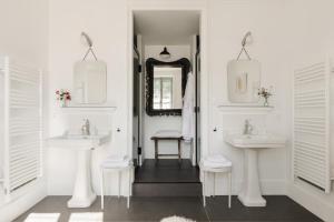 a white bathroom with two sinks and a mirror at La Cour de Beaune in Beaune +24 photos