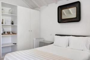 1 dormitorio con cama blanca y espejo en la pared en Casa do Mestre Studio e Suíte Extra, en Vila de Punhe 22 fotos más