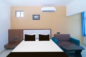 una habitación de hospital con una cama y una silla en Hotel O MG International, en Jamshedpur