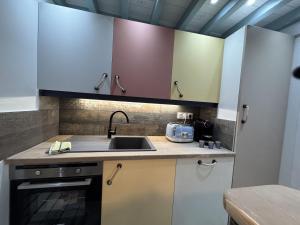 a kitchen with white cabinets and a sink at Riva Bella Marine in Ouistreham