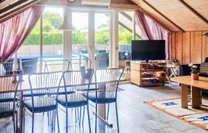 a living room with a table and chairs and a television at Nice Home In Hemmet With Sauna in Hemmet