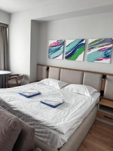 a bedroom with a bed with two plates on it at Апартаменты в новом отеле Радуга Вест in Koshkolʼ