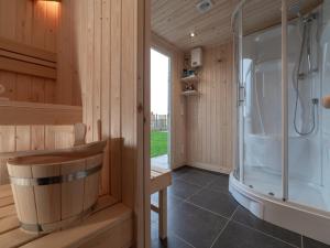 a wooden bathroom with a shower and a tub at Coast Calm 71 in Colijnsplaat +17 photos