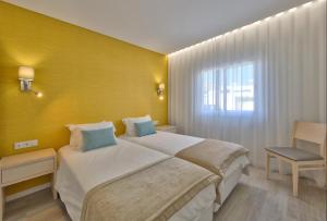 a hotel room with a large bed and a window at Agua Hotels Vila Branca in Lagos
