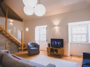 a living room with a couch and a tv at Casa p'ra Muralha in Óbidos