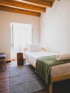 a bedroom with a bed and a window at Casa p'ra Muralha in Óbidos