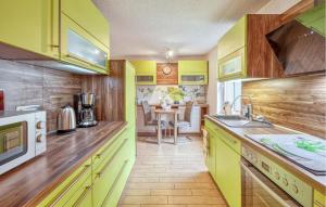 una cucina con armadi gialli e tavolo di Amazing Home In Breesen Ot Kalübbe  Altre 22 foto
