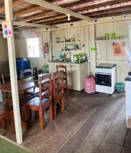 a kitchen with a table and chairs and a stove at HOSTEL MAIANDEUA in Algodoal +47 photos