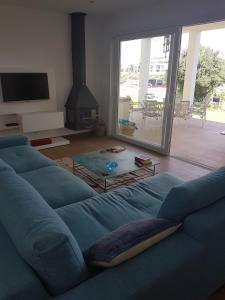 a living room with a blue couch and a fireplace at Agua en las Rocas in Sa Caleta
