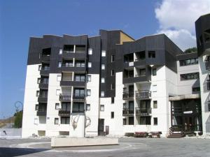 a large white building with a black roof at Charmant studio cabine 4 pers. aux Bruyères, pied des pistes, animaux permis - FR-1-452-7 in Les Menuires