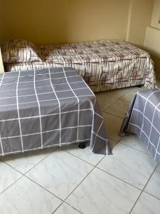 a bedroom with a bed with a covering on the floor at Hostel casa amarela in Búzios