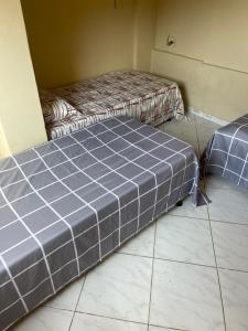 two beds in a room with a tiled floor at Hostel casa amarela in Búzios