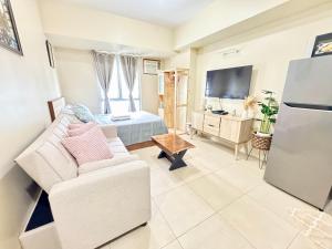 a living room with a couch and a television at Condo Unit inside IT Park Lahug Cebu City in Cebu City +5 photos