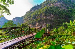 a bridge with a mountain in the background at Hoang Minh Mountainside Villa in Ninh Binh +80 photos
