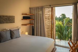 a bedroom with a bed and a large window at Casa Mia El Cuyo Eco Beach Boutique Hotel Sin Aire Acondicionado in El Cuyo