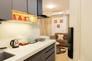 a kitchen with a white counter top in a room at Airport Aura 5 Min Walk to Airport in Pune