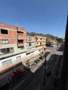 uma vista para uma rua da cidade com edifícios e um carro vermelho em Apartment 304 em Itagüí