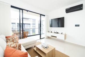 Una sala de estar con un sofá y un televisor. en Spacious 3BD Penthouse Private Rooftop Sea Breeze, en San Rafael del Yuma