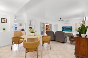ein Wohnzimmer mit Tisch und Stühlen in der Unterkunft Letizia Lakes - Resort Style Living in Cairns North