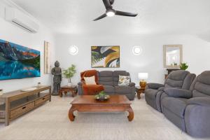 ein Wohnzimmer mit Sofa und Tisch in der Unterkunft Letizia Lakes - Resort Style Living in Cairns North + 12 Fotos