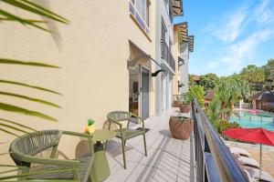 einen Balkon mit Stühlen, einem Tisch und einem Pool in der Unterkunft Letizia Lakes - Resort Style Living in Cairns North