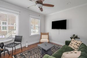 a living room with a couch and a flat screen tv at Rose carriage House Savannah in Savannah