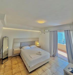 een slaapkamer met een wit bed en een groot raam bij Larisa City Ap 5 with parking in Larisa