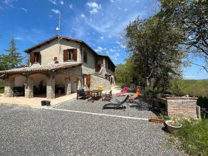 a large stone house with a patio in front of it at Appartamento in casale Umbro vicino Orvieto - Allerona in Allerona