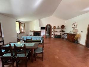 a living room with tables and chairs and a kitchen at Appartamento in casale Umbro vicino Orvieto - Allerona in Allerona
