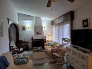 a living room with a couch and a flat screen tv at Descanso en Piriápolis in Piriápolis