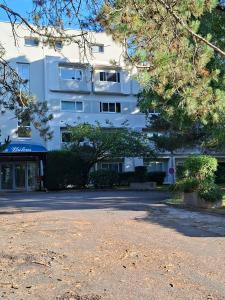 a white building with a parking lot in front of it at Appartement neuf proche Nantes avec parking in Carquefou