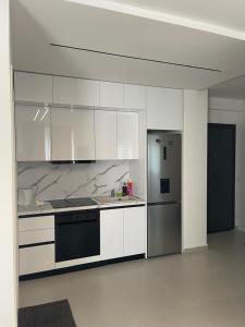 a kitchen with white cabinets and a stainless steel refrigerator at Mel Apt in Golem